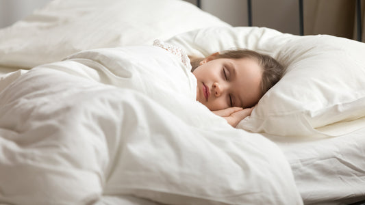 Calm adorable little daughter take day nap. Tranquil preschool child girl covered with white fresh duvet lying in bed comfortable mattress on bedroom. 